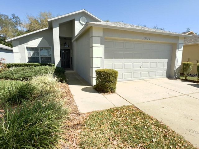 view of front of home featuring stucco siding, concrete driveway, and a garage