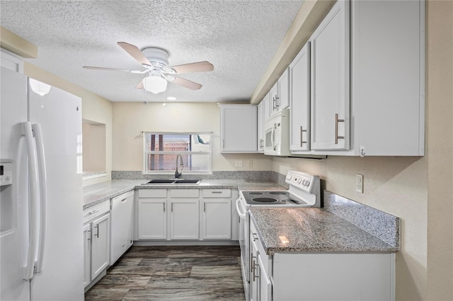 kitchen featuring white appliances, dark wood finished floors, light stone countertops, white cabinetry, and a sink