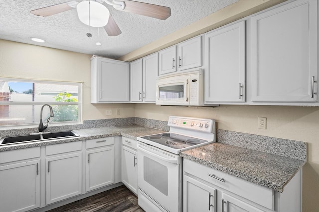kitchen featuring white appliances, a sink, and white cabinetry