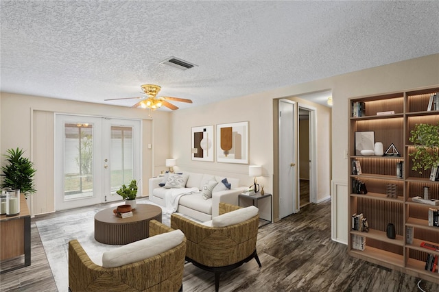 living room with ceiling fan, a textured ceiling, visible vents, french doors, and dark wood-style floors