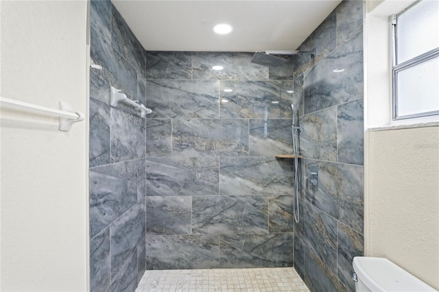 full bath featuring toilet and a tile shower