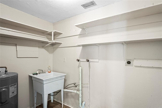 clothes washing area with laundry area, visible vents, electric water heater, hookup for a washing machine, and hookup for an electric dryer