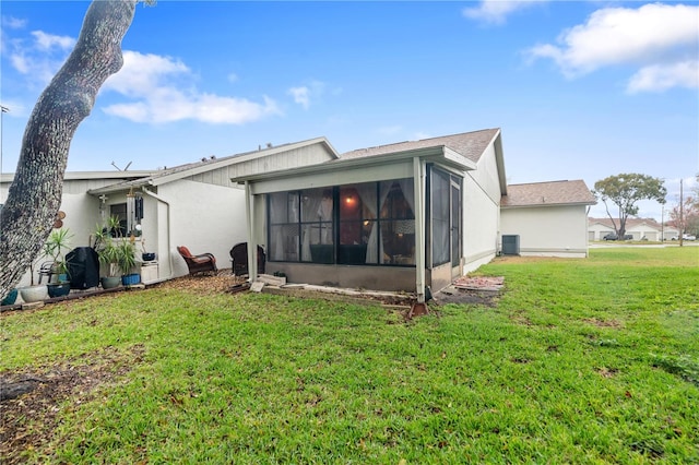 back of house featuring cooling unit, a sunroom, and a yard