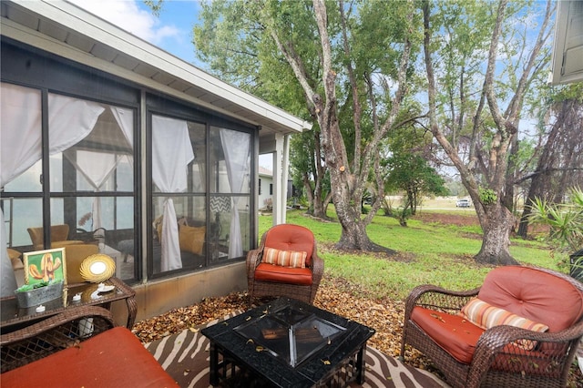 view of patio / terrace with a sunroom and an outdoor fire pit