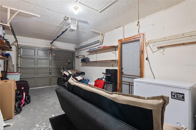 garage with concrete block wall, fridge, and a garage door opener