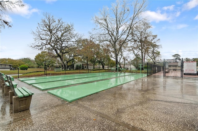 view of home's community with a gate, shuffleboard, and fence