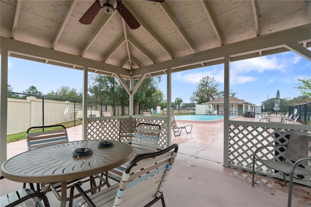 sunroom / solarium with vaulted ceiling, a ceiling fan, and a healthy amount of sunlight