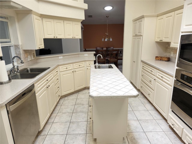 kitchen featuring light tile patterned floors, a center island with sink, stainless steel appliances, and a sink