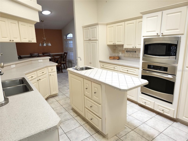 kitchen with backsplash, stainless steel appliances, light countertops, and a sink