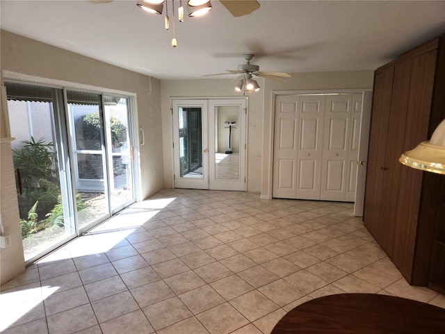 spare room featuring light tile patterned floors, french doors, and a ceiling fan