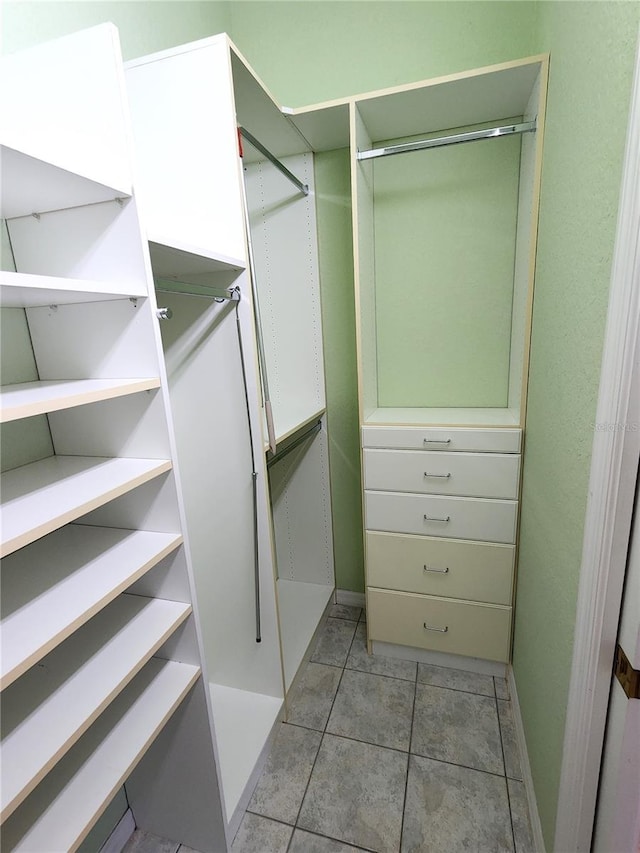 walk in closet with light tile patterned floors