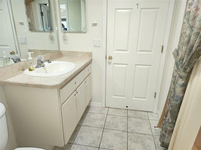 bathroom with tile patterned floors, toilet, vanity, and baseboards