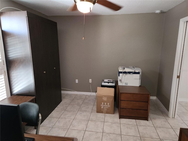 home office featuring light tile patterned floors, baseboards, and ceiling fan