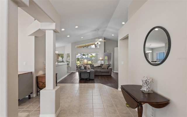 entryway featuring decorative columns, lofted ceiling, light tile patterned floors, and ceiling fan