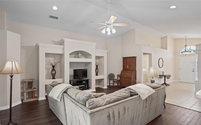 living room with hardwood / wood-style flooring, high vaulted ceiling, built in features, and ceiling fan