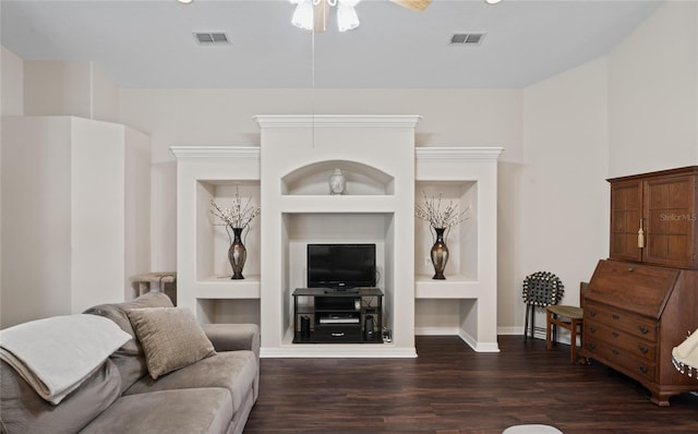 living room with built in shelves, dark hardwood / wood-style floors, and ceiling fan