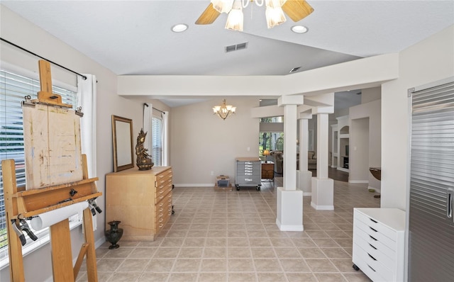 interior space featuring ceiling fan with notable chandelier, a healthy amount of sunlight, and light tile patterned flooring