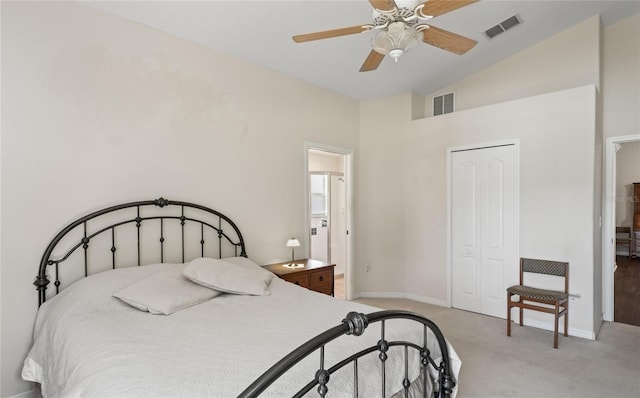 bedroom with vaulted ceiling, light colored carpet, ceiling fan, and a closet