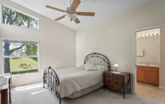 bedroom with multiple windows, sink, vaulted ceiling, and light colored carpet