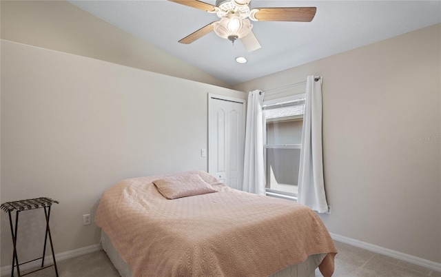 bedroom featuring lofted ceiling, light colored carpet, a closet, and ceiling fan