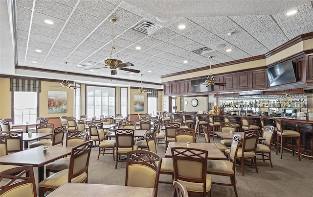 dining area featuring crown molding, ceiling fan, a healthy amount of sunlight, and carpet