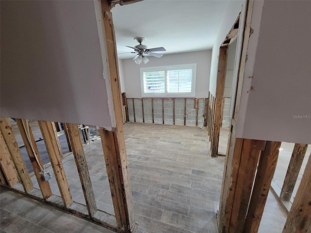 stairs featuring wood-type flooring and ceiling fan