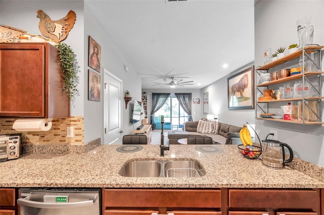 kitchen featuring sink, dishwasher, ceiling fan, backsplash, and light stone counters