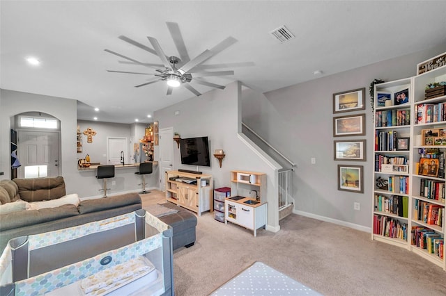 carpeted living room with sink and ceiling fan