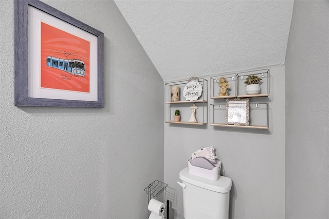 bathroom featuring vaulted ceiling, a textured ceiling, and toilet