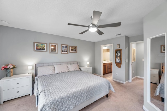 carpeted bedroom with ceiling fan, connected bathroom, and a textured ceiling