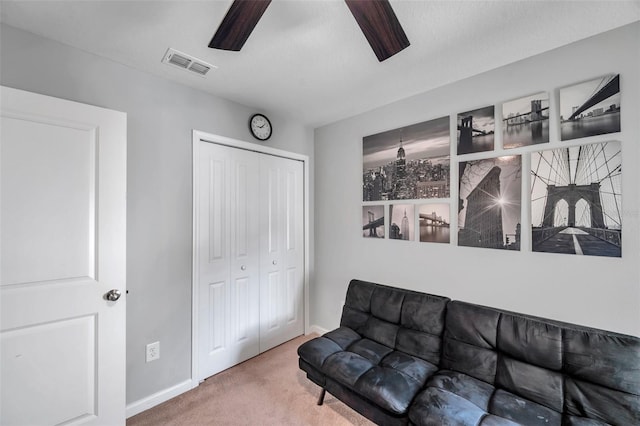 sitting room with ceiling fan and carpet