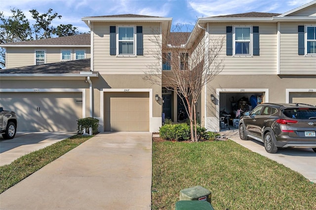 townhome / multi-family property with a garage and a front lawn