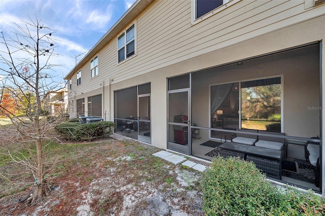 rear view of house with an outdoor living space and a sunroom