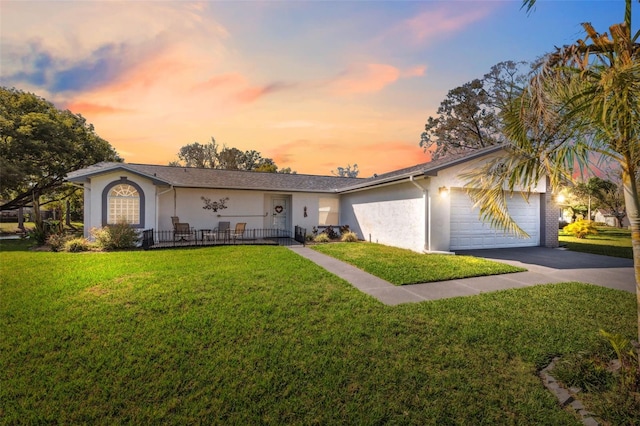 ranch-style house with a garage and a lawn