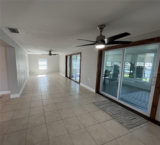 tiled spare room featuring ceiling fan