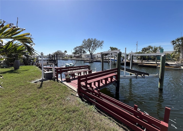 dock area with a lawn and a water view