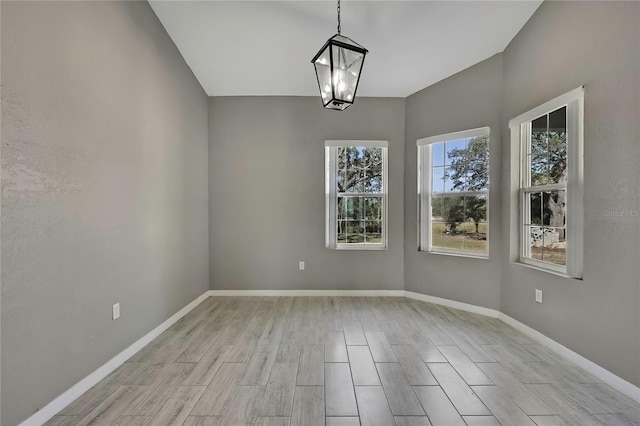 unfurnished dining area featuring a notable chandelier