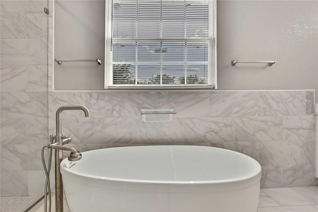 bathroom with a bathing tub and tile walls