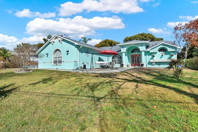 rear view of house with a yard and a patio area