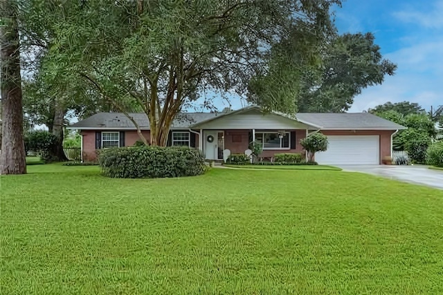 single story home featuring a garage and a front lawn