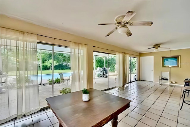 doorway with ceiling fan and light tile patterned flooring