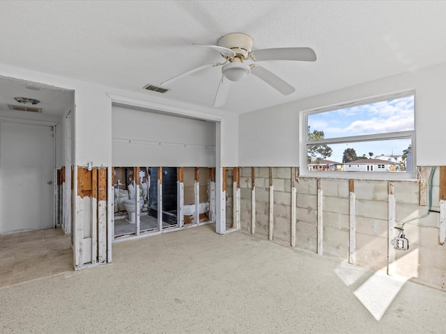 interior space with a textured ceiling and ceiling fan