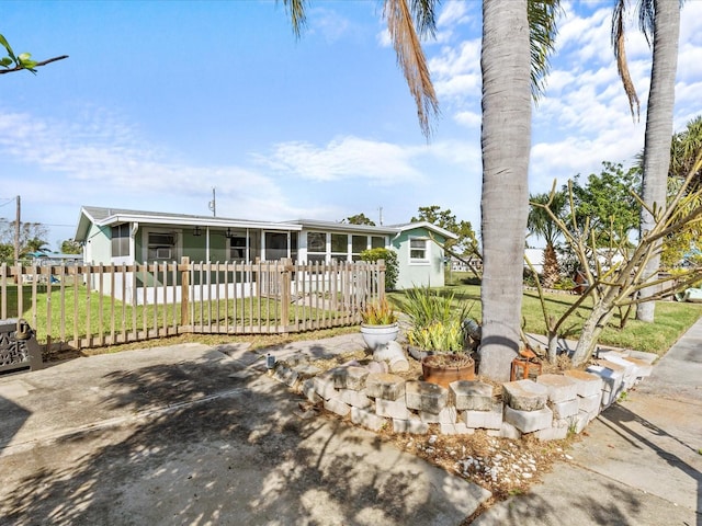 view of front of property with a sunroom and a front lawn