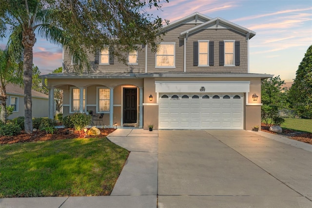 view of front of property with a yard, a garage, and a porch