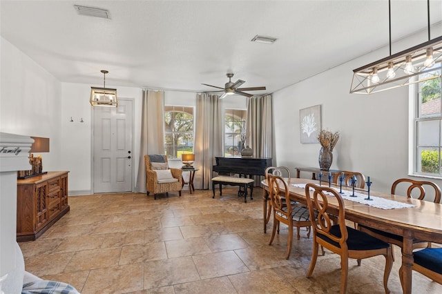 dining space with ceiling fan and a textured ceiling