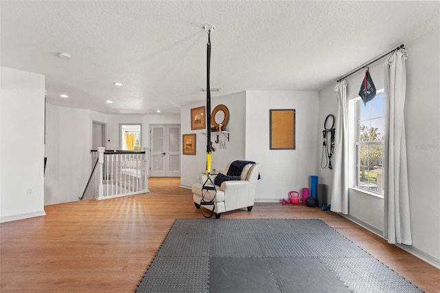 workout room with light hardwood / wood-style flooring and a textured ceiling