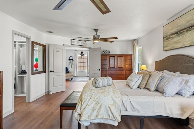 bedroom with ceiling fan, wood-type flooring, multiple windows, and a textured ceiling