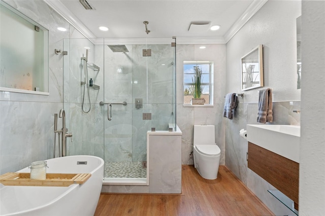 full bathroom with tile walls, hardwood / wood-style flooring, ornamental molding, vanity, and toilet