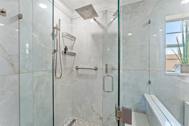 bathroom featuring a wealth of natural light, ornamental molding, and a shower with door