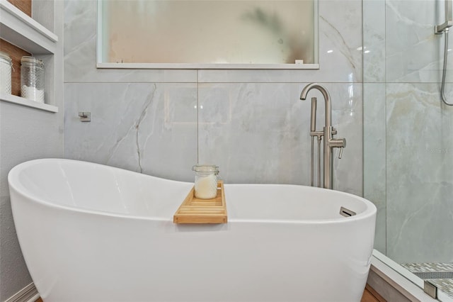 bathroom featuring tile walls and independent shower and bath